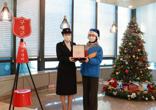 CJ대한통운 직원(오른쪽)이 구세군 사관으로부터 감사패를 전달 받고 기념촬영을 하고 있다. <CJ대한통운 제공>